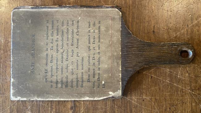 The College Grace printed on a wooden paddle